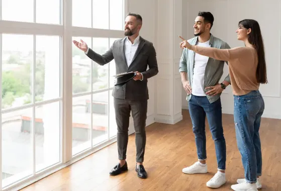 Agent immobillier Swixim présentant un bien à vendre a un couple venu visiter un appartement